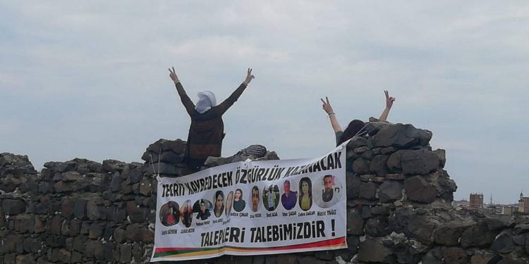 Jinan li ser sûrên Amedê li dijî tecrîdê pankart daliqandin