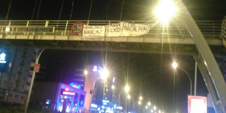 Ciwanên Amedê pankarta “Em ê destên ku li dijî dayikan radibe bişkînin, tecrîdê parçe bikin” daliqandin