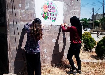 YJC afîşên rengîn “Jin Jiyan Azadî Serbixe Azadî” li kolanên Kobanê