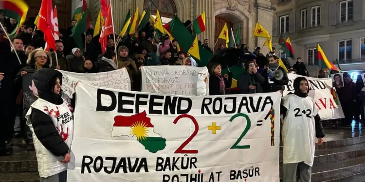 Pankartek Bi Nivîsa “Rojava Biparêze” Li Ser Avahiya Ku Peymana Lozanê Lê Hatiye Imzekirin Hate Daliqandin