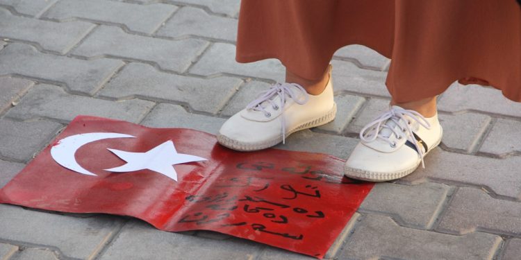 Genç kadınlar, işgalci Türk devletinin bayrağını ayaklar altına aldı