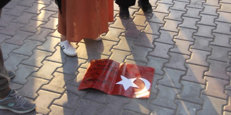 Genç kadınlar, işgalci Türk devletinin bayrağını ayaklar altına aldı