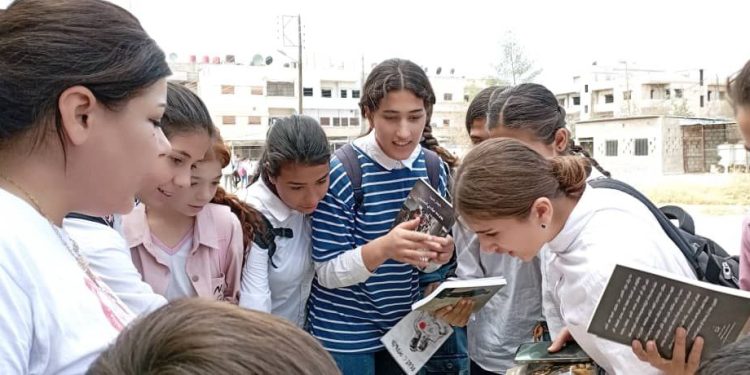 Hesekê’li genç kadınlar, Önder Apo’nun kitaplarını dağıtıyor
